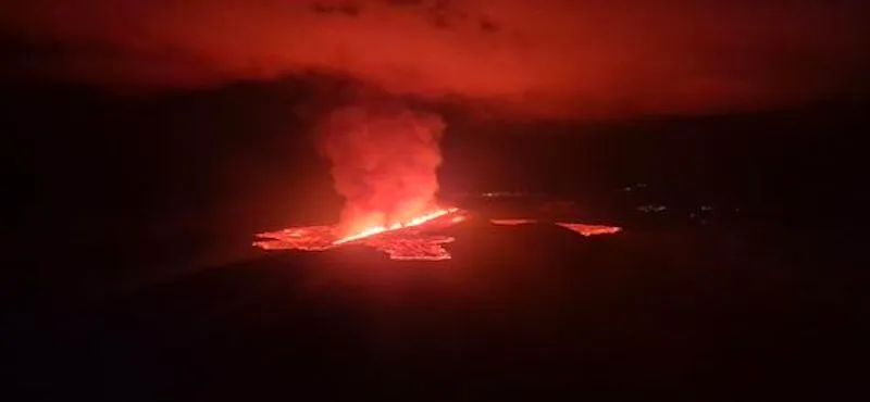 The fissure opening around midnight taken from the Coast Guard helicopter. Lights in the town of Grindavík seen in the distance. (Photo: Civil Protection/Björn Oddsson)